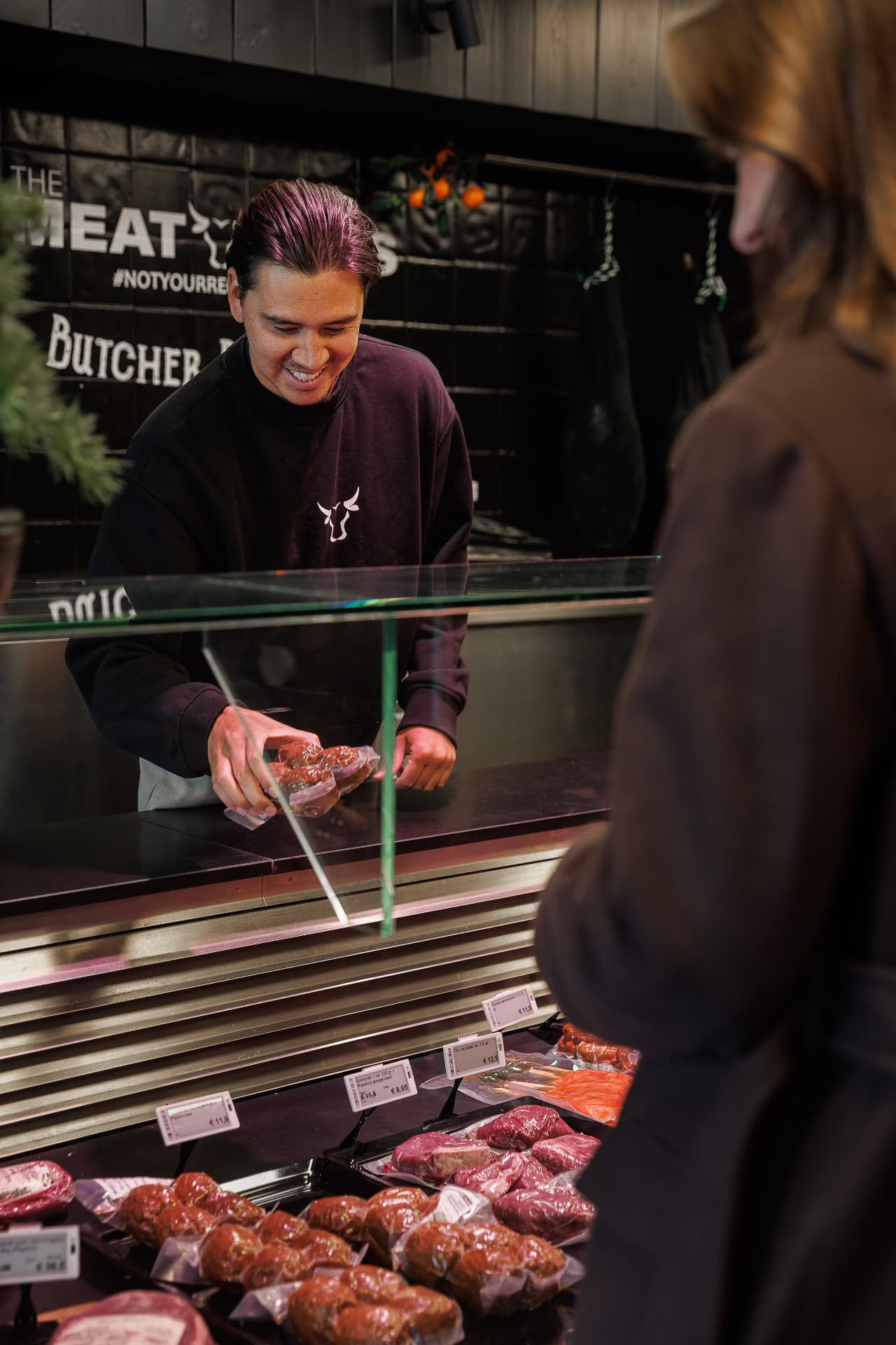 Bediening achter de toonbank van de Butcher Boutique